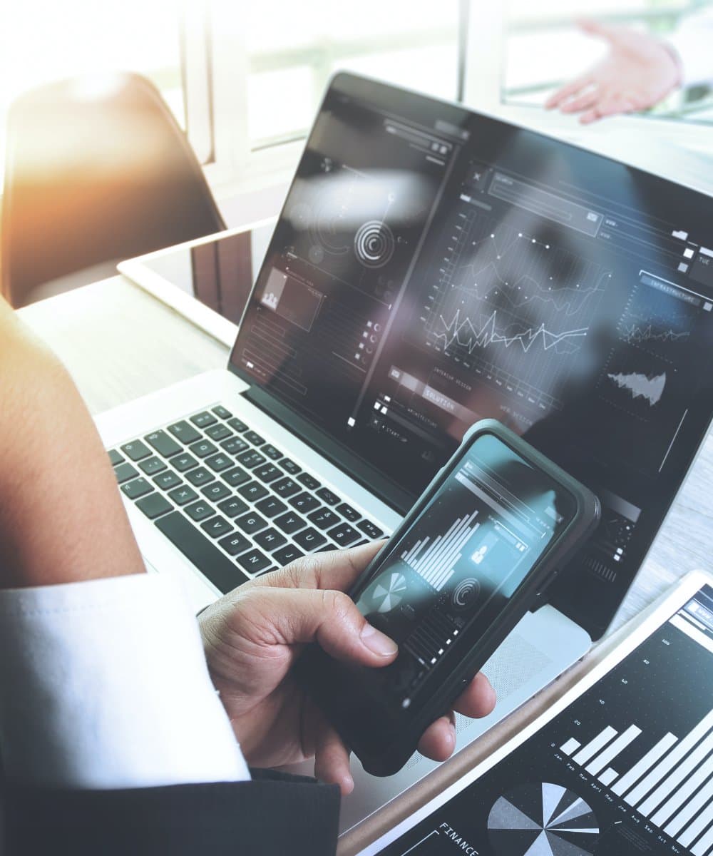 Reviewing market analytics on a laptop and phone